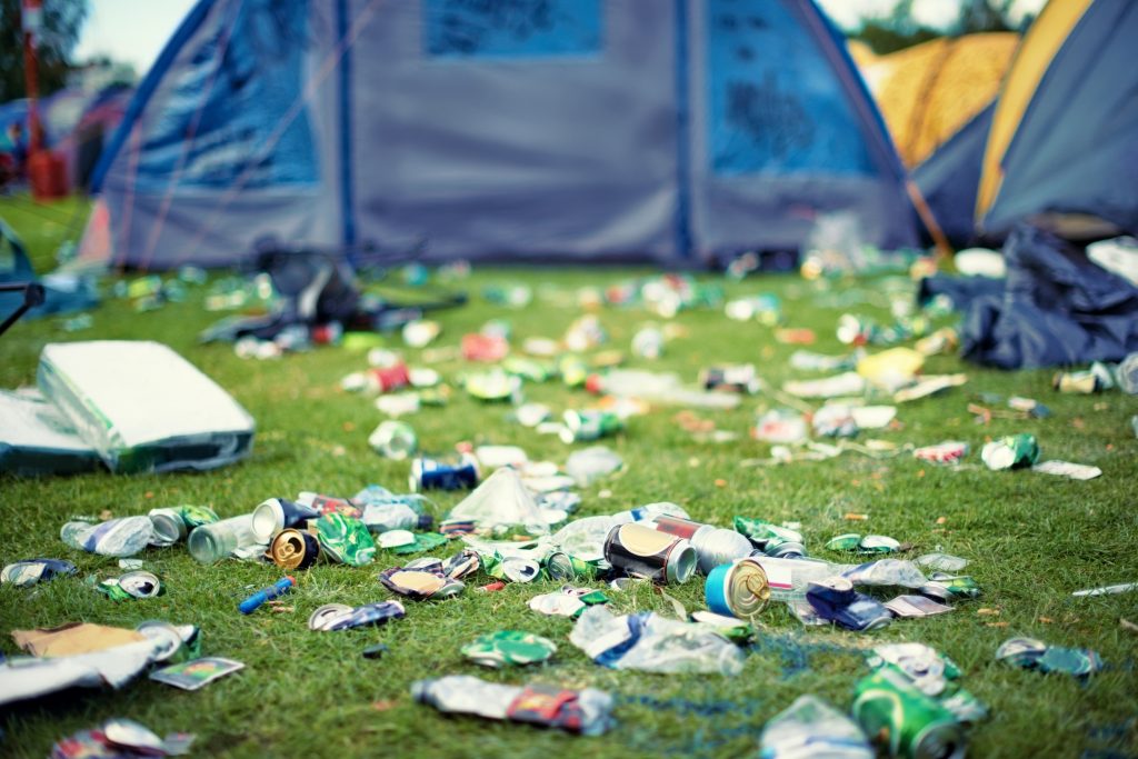 event waste showing old cans and plastic bottoms on a festival field