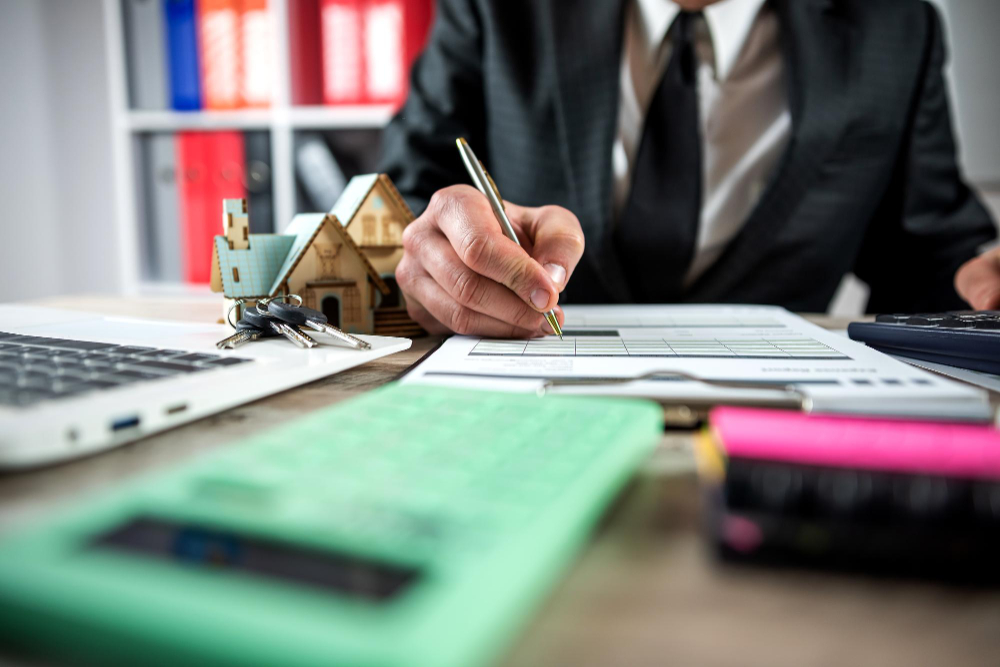 probate house clearance contract being signed by a man with a pen with a small image of a house in the background